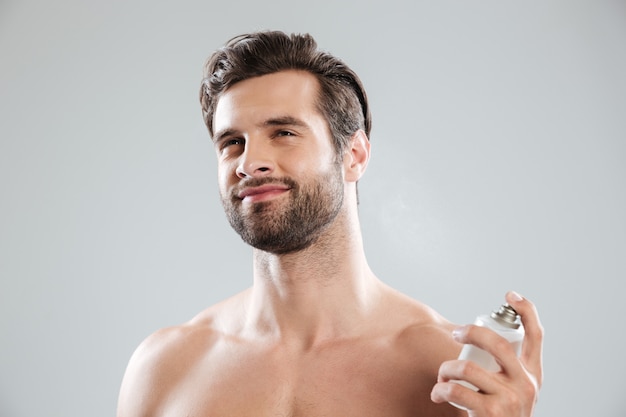 Man using perfume isolated