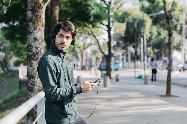 電話を使って音楽を聴いている男