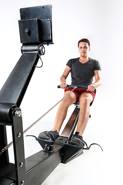 Free photo man using a press machine in a fitness club.