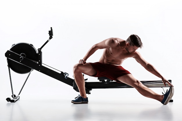 Free photo man using a press machine in a fitness club.