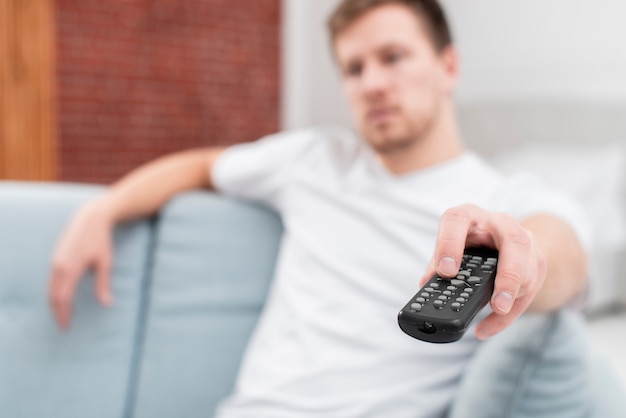 Man using the remote to change channels close-up