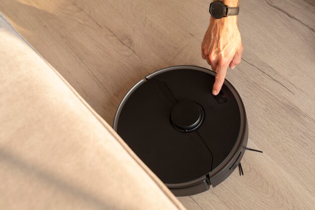 Man using a robot vacuum in the living room