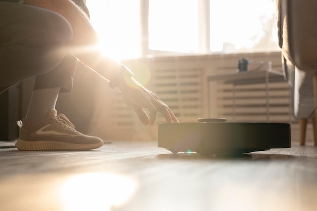 Man using a robot vacuum in the living room