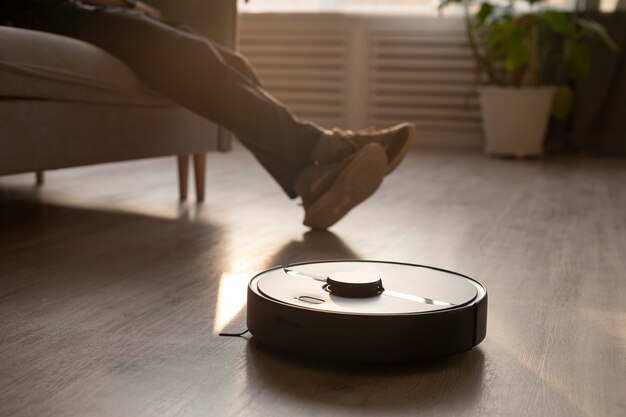 Man using a robot vacuum in the living room