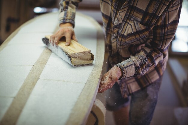 Man using sanding block in workshop