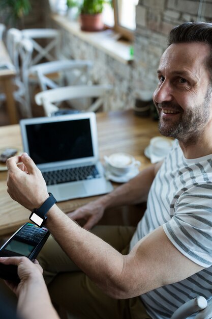 Человек с помощью смарт-часы для экспресс-оплаты в кафе