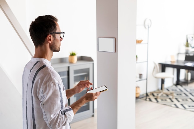man using a smartphone in his automated home