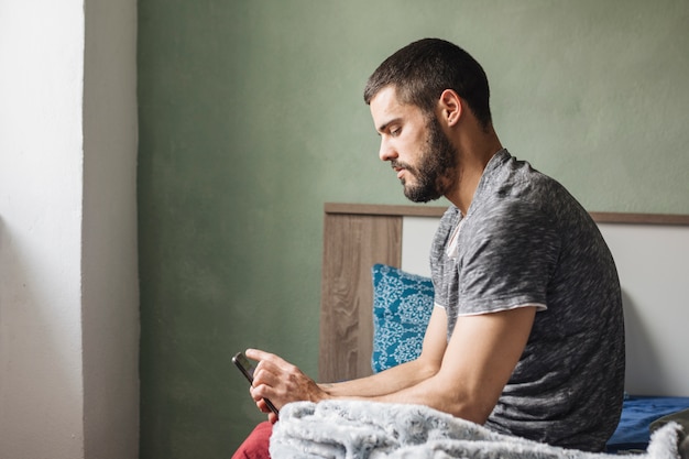 Man using smartphone at home