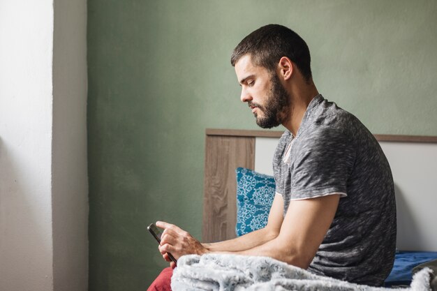 Man using smartphone at home