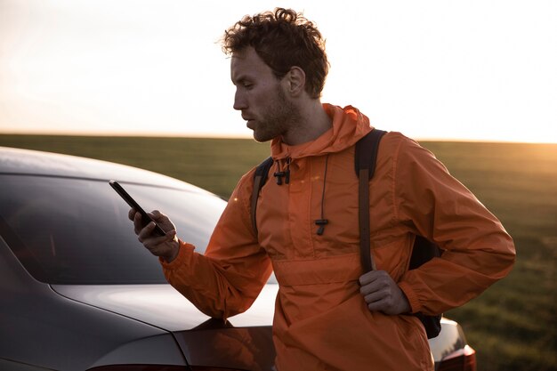 Man using smartphone outdoors while on a road trip