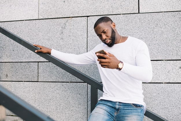 Man using smartphone on staircase