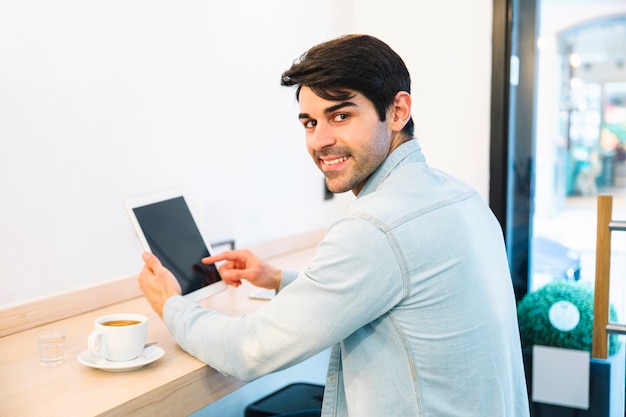 Man using tablet looking behind