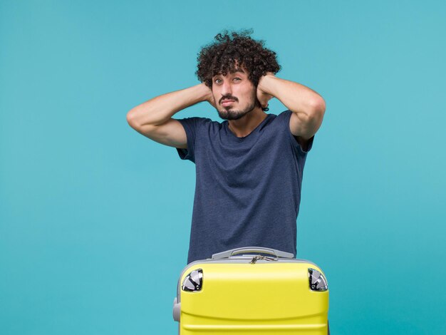 man in vacation in blue t-shirt closign his ears on blue