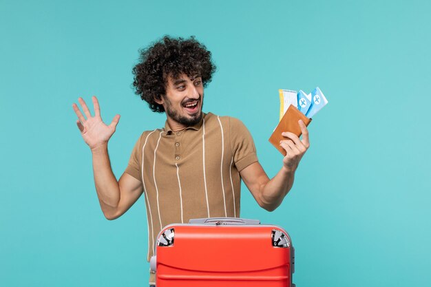 man in vacation holding tickets on blue