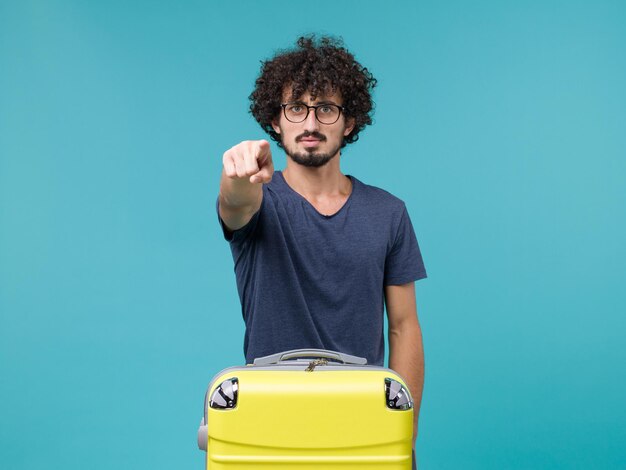 man in vacation with big suitcase on blue