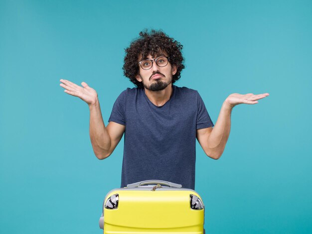 man in vacation with big suitcase on blue