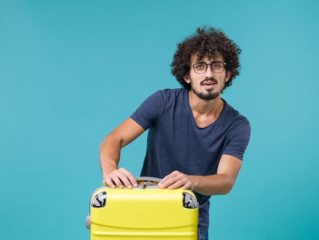 Free photo man in vacation with big suitcase on light blue