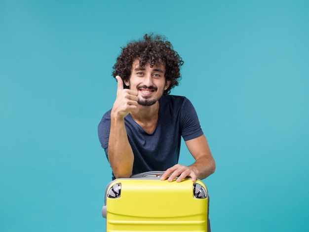 man in vacation with his yellow suitcase on blue