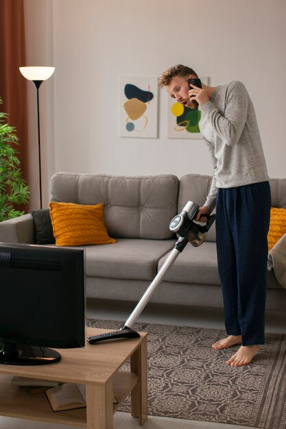 Man vacuuming and watching tv side view