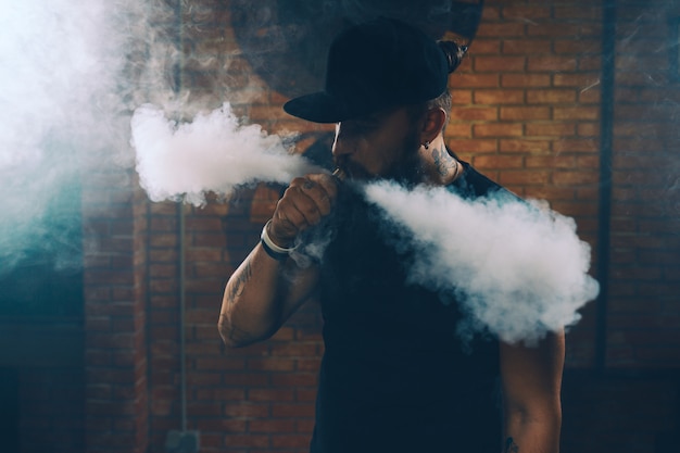 Free photo man vaping an electronic cigarette