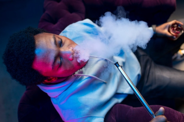 Man vaping from a hookah indoors