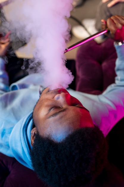 Man vaping from a hookah indoors