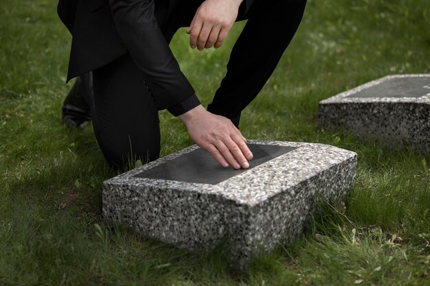 Man visiting gravestone at the cemetery