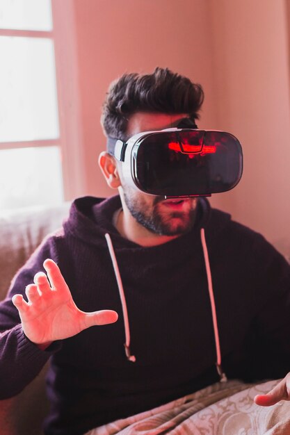 Человек в гарнитуре VR на диване