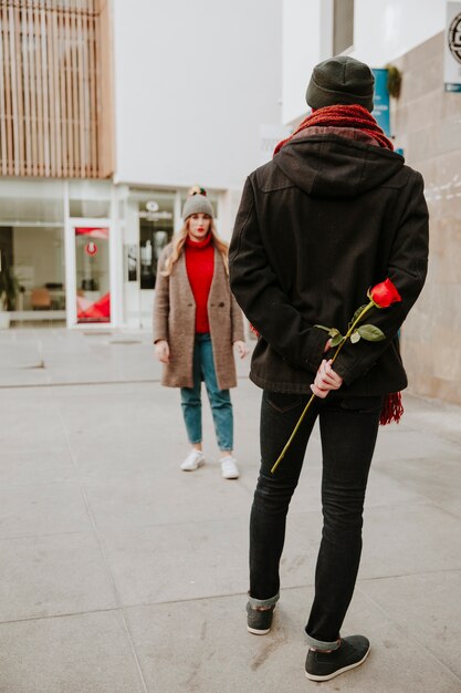 Мужчина ждет подругу с розой