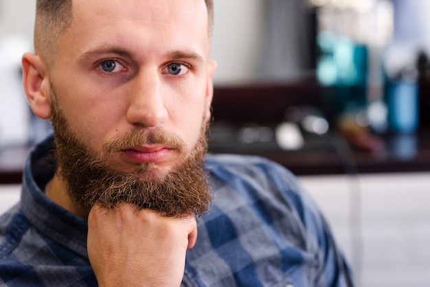 Foto gratuita uomo in attesa di un taglio di capelli presso il negozio di barbiere