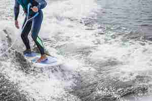 Foto gratuita uomo su wakesurfing. saluta dalla barca.