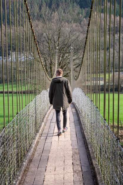 A man walking over a bridge