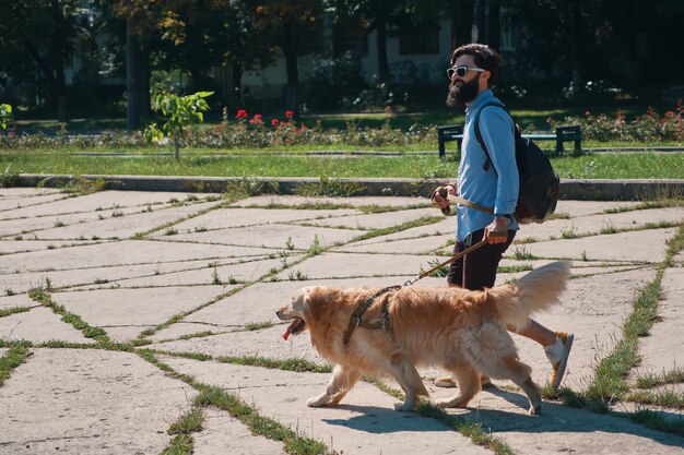 Человек гуляет со своей собакой в парке