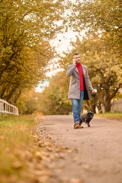 公園で犬と一緒に歩く男