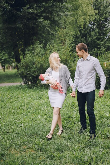 Man walking with his wife while she is carrying her baby in her arms