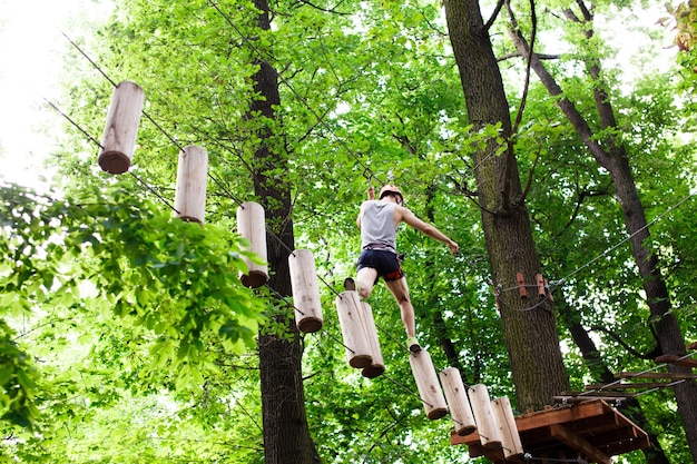 Free photo man walks on the rope path in the air