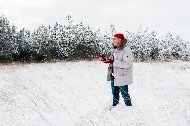 Man in warm jacket standing in winter forest 