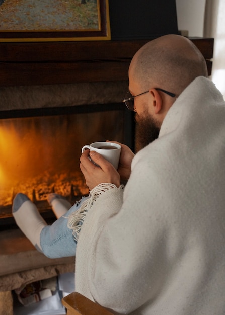 Man warming at fireplace during energy crisis