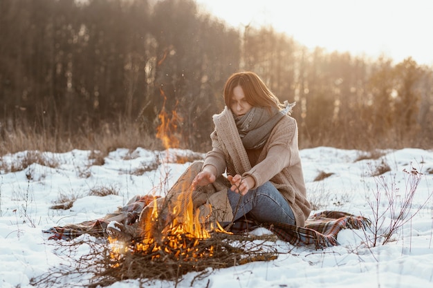 Man warming up next to a campfire in winter