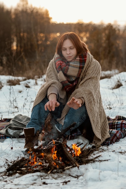 Man warming up next to a campfire in winter