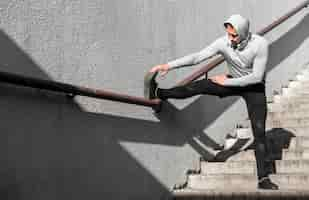 Free photo man warming up his legs using a railing