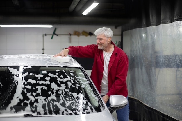 Free photo man washing a car