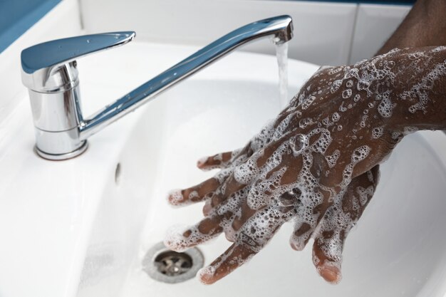 Man washing hands carefully with soap and sanitizer, close up. Prevention of pneumonia virus spreading, protection against coronavirus pandemia. Hygiene, sanitary, cleanliness, disinfection. Safety.