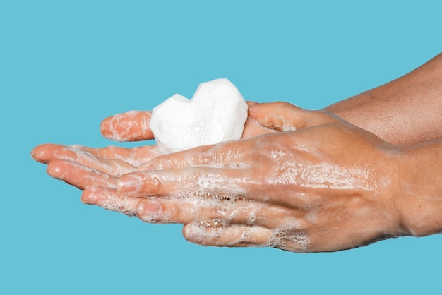 Мужчина моет руки белым мылом в форме сердца