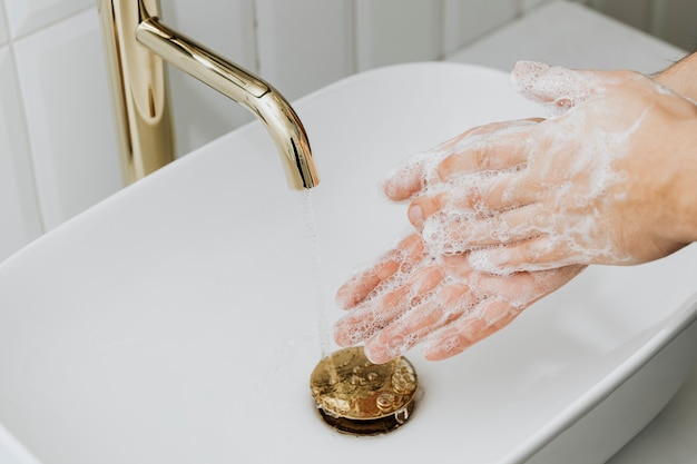 Free photo man washing hands with soap