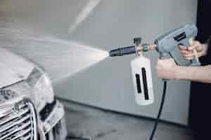 Free photo man washing his car in a garage