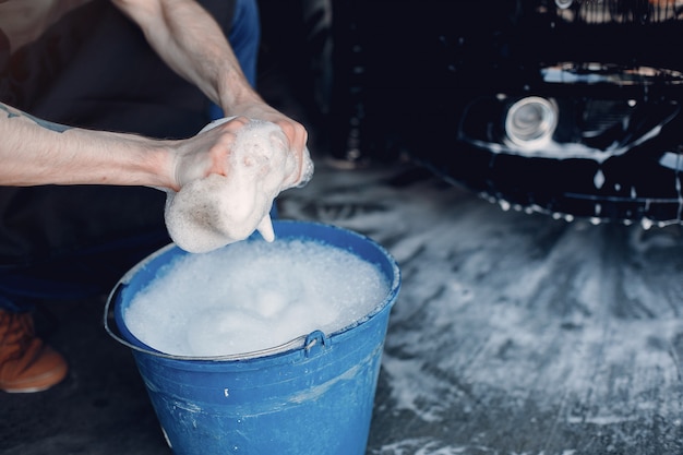 Man washing his car in a garage