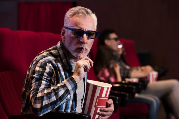 Free photo man watching movie in cinema