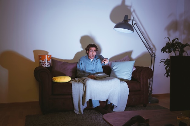 Foto gratuita uomo che guarda un film sul divano