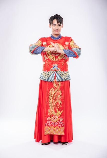 Man wear cheongsam smile and is standing and respect customer who come to shop in chinese new year